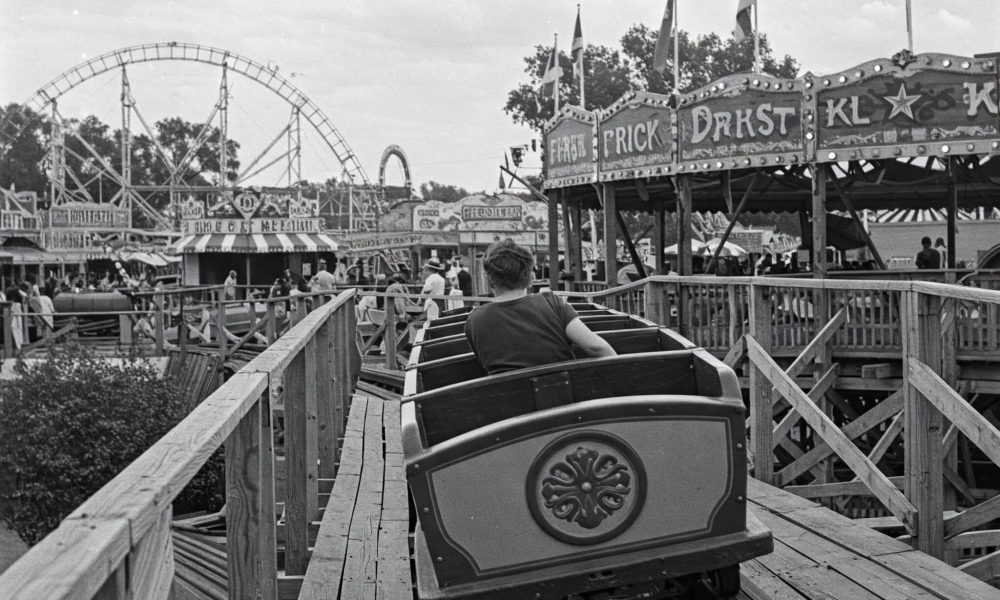 Black and white photo of an aman riding a roller coaster in an historical amusement park in Texas